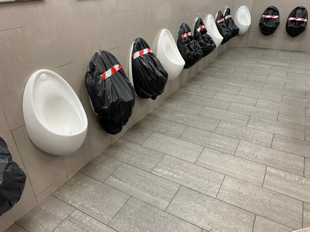 Záběr na pánské toalety ukazuje, že odstup je nutné dodržovat i na tomto místě. Fotografie je z města Maidstone ve Velké Británii