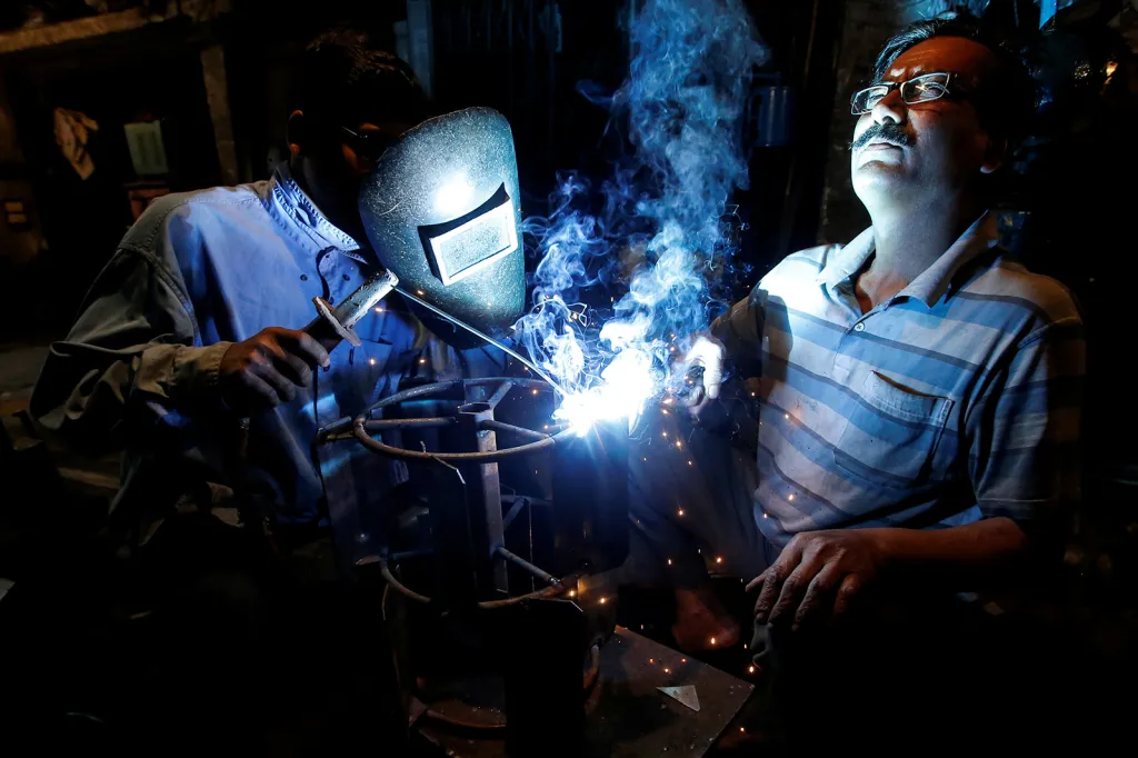 Dělníci na předměstí Kalkaty svařují železný rám, který bude použit při orbě pole