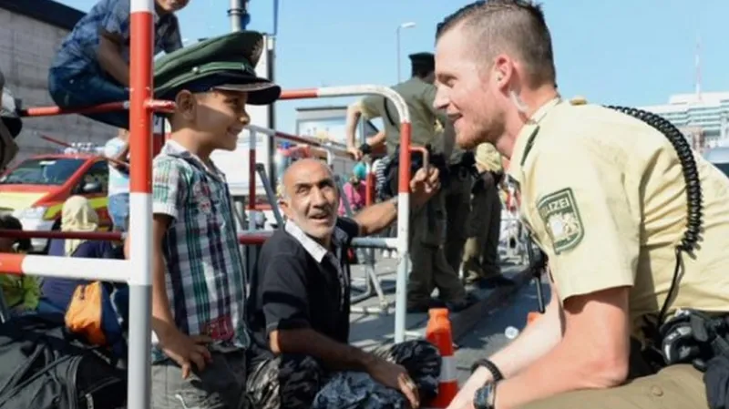 Policista žertuje s uprchlíky