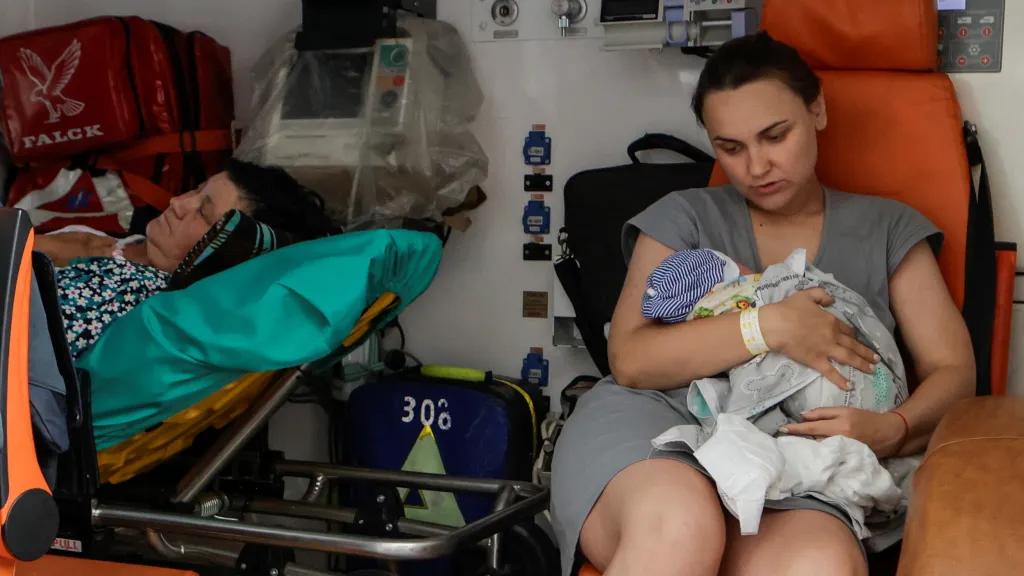 Matka s dítětem v sanitce během evakuace z porodnice v centru Charkova poškozené ruským dronem (11. července 2025)