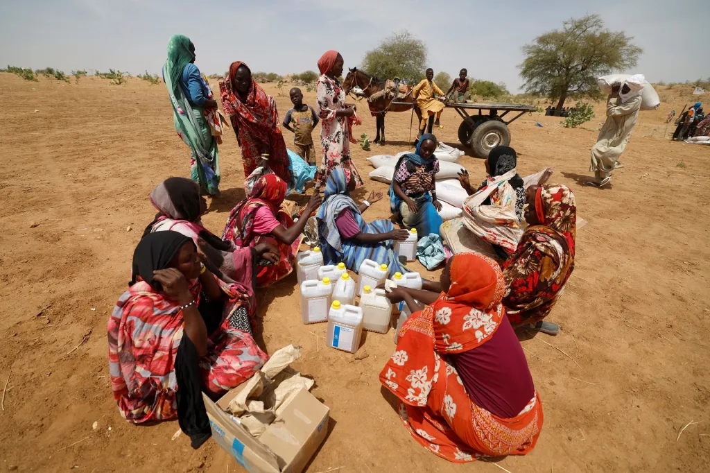 Súdánští uprchlíci mezi sebou rovnoměrně přerozdělují jídlo a vodu, kterou dostali od Světového potravinového programu, organizace v rámci OSN