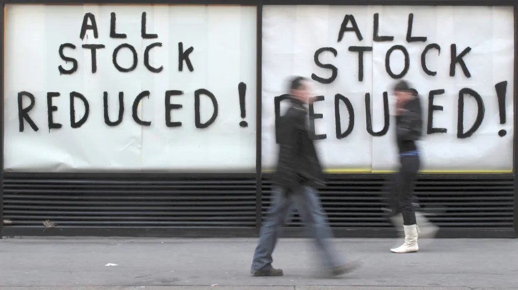 Chodci před výlohami s nápisem Výprodej v centru Londýna v prosinci 2009. Mnoho obchodů muselo po desetiletích úspěšné činnosti ukončit provoz. Rok 2009 byl pro Británii nejhorším od dob 2. světové války. Počet nezaměstnaných překročil dva miliony
