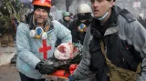 Aktivisté odvážejí zraněného demonstranta