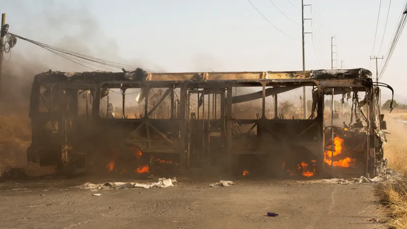 Hořící autobus, který zločinci použili jako zátaras během operace, při níž zemřel drogový boss Nemesio Rubén Oseguera Cervantes (22. února 2026)