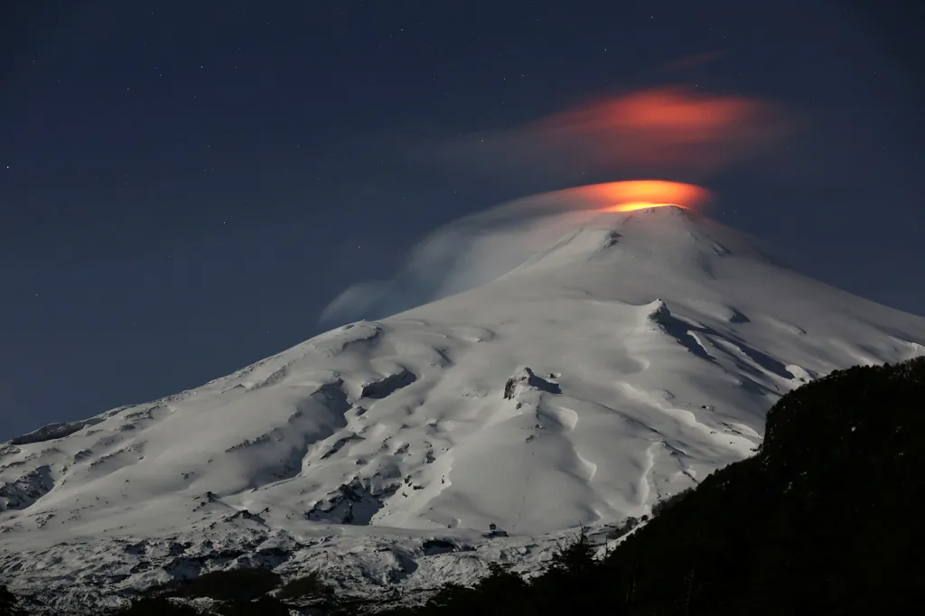 Noční pohled z chilského města Pucon na sopku Villarrica během erupcí