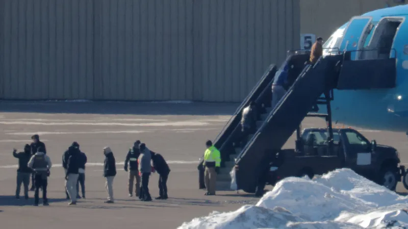 Na mezinárodním letišti Minneapolis – St. Paul nastupují do letadla zadržené osoby, které čeká deportace