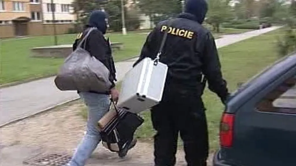 Policisté odnášejí zabavené věci