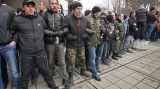 Proruští demonstranti se sepjatými pažemi stojí proti davu krymských Tatarů