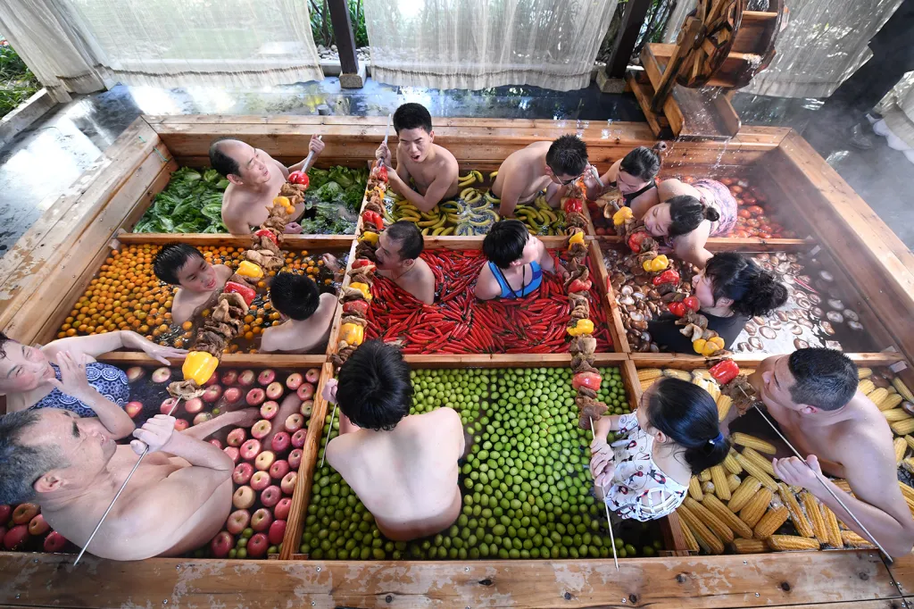 Lidé se koupají v horkých pramenech v bazéncích naplněných čerstvým ovocem a zeleninou v čínském městě Chang-čou