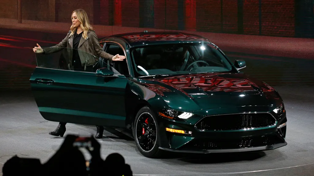 Molly McQueenová (vnučka herce Stevea McQueena) představuje novinku detroitského autosalonu - Ford Mustang Bullitt. Jeho název pochází z filmu Bullittův případ, jehož hrdinou je slavné filmové auto detektiva ze San Franciska.