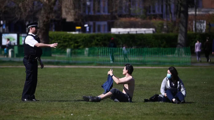 Policista hovoří s lidmi v londýnském Greenwich Parku