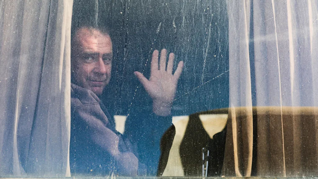 Palestinec mává z okna na hraničním přechodu Rafah, přes který ranění a pacienti v doprovodu svých příbuzných opustili Gazu, 3. února 2026