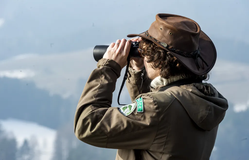 Strážce Národního parku České Švýcarsko sleduje vrtulník, s jehož pomocí nový altán na vyhlídku umístili