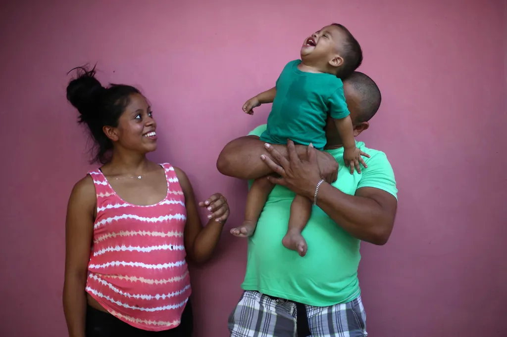 Rolando Bueso (37 let) deportovaný kvůli tvrdé imigrační politice Trumpovy administrativy se svým synem Johanem (15 měsíců) a jejich matka Adalicia Montecino (21 let) při společném setkání a přípravě na fotografování před jejich domem ve městě La Libertad v Hondurasu.