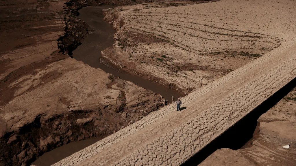 Muž se prochází po popraskaném povrchu katalánské nádrže Baells, kde se zásoby pitné vody v důsledku extrémního sucha propadly na nejnižší úroveň od roku 1990