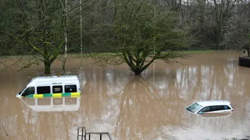 Sanitka s dalším osobním autem jsou ponořeny po povodních v Nantgarw ve Walesu