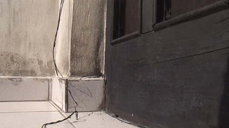 Na dveřích domu jsou stále viditelné pozůstatky požáru