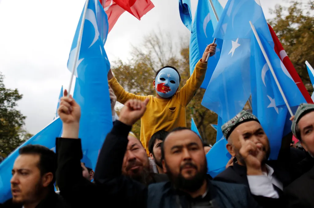 Maskovaný ujgurský chlapec se účastní protestu proti Číně na nádvoří mešity Fatih, společného místa setkávání proislamistických demonstrantů v tureckém Istanbulu
