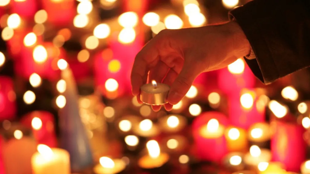 Pražští občané zapalují svíčku jako upomínku na násilný zásah SNB proti studentům