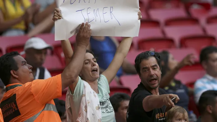 Olympijská ochranka se snaží vzít ženě plakát s heslem: „Pryč s Temerem“