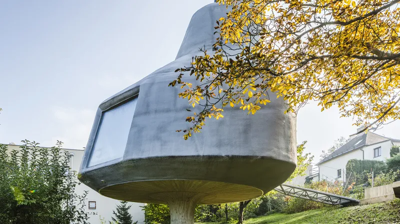 Na svažitém pozemku v Praze – Kyjích vyrostl organický rodinný dům, který je navržen jako dřevostavba s železobetonovým založením ve tvaru betonové stopky.