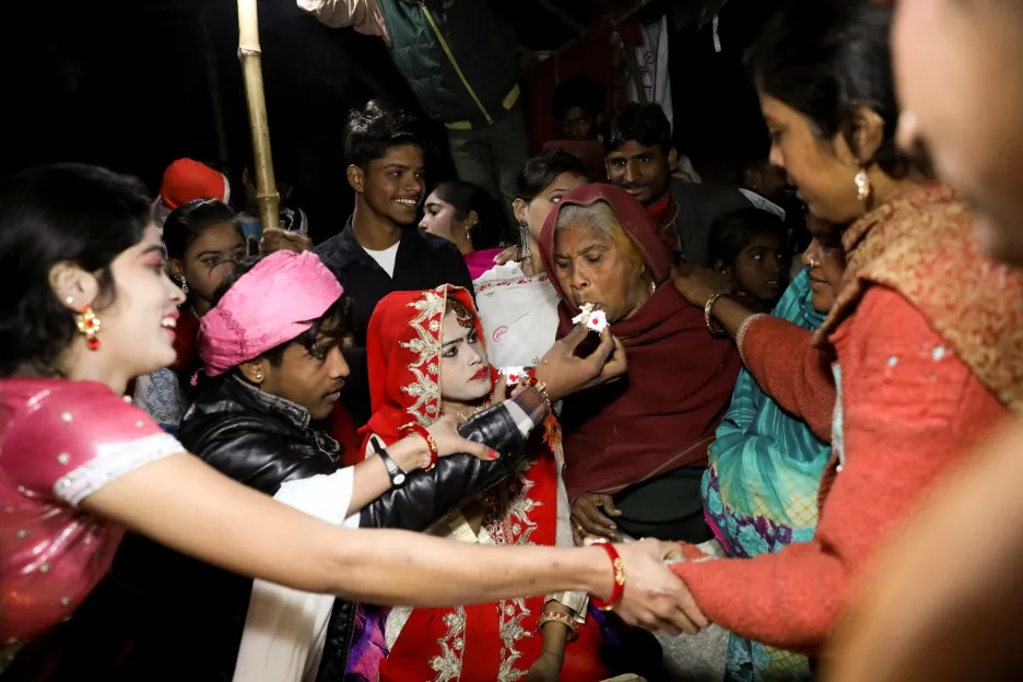 Hinduisty spojuje soudržnost v rodině. Na fotografii dává mladík před svojí svatbou dort babičce. Oslava se konala v hinduistické uprchlické osadě poblíž mostu Signature Bridge