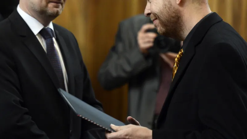 Ministr školství Petr Fiala (vlevo) předává dekret profesoru Martinu C. Putnovi (vpravo)