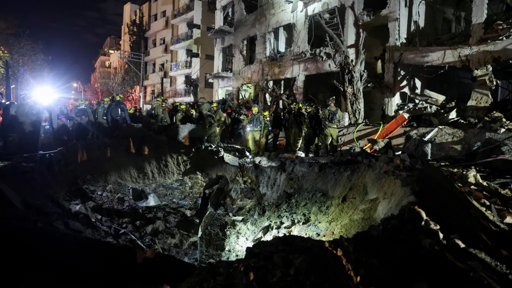 Izraelští záchranáři prohlížejí v Tel Avivu kráter v místě dopadu projektilu poté, co Írán vystřelil rakety na Izrael, 1. března 2026