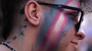 Člověk s transgender vlajkou na obličeji