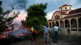 Lidé se snaží zastavit požár u kostela ve městě Rafina
