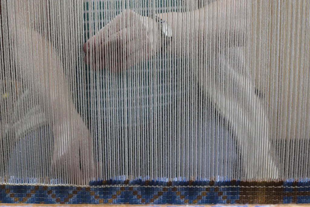 V Česku zároveň neexistuje jiná dílna pro výrobu reprezentativních velkých ručně tkaných koberců. Pět tisíc uzlů za směnu, 15 řádků za den, půl milionu uzlů na jeden koberec.