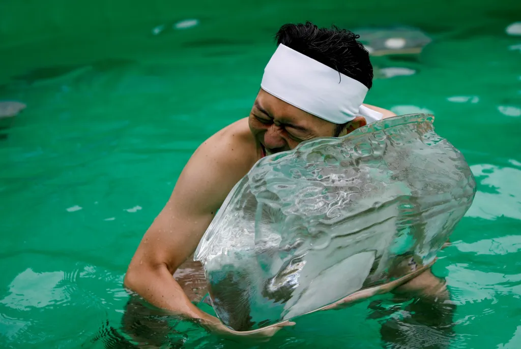 Muž drží cihlu ledu během obřadu v ledové vodě, aby očistil svoji duši. Rituál se odehrál ve svatyni Teppozu Inari v Tokiu v Japonsku
