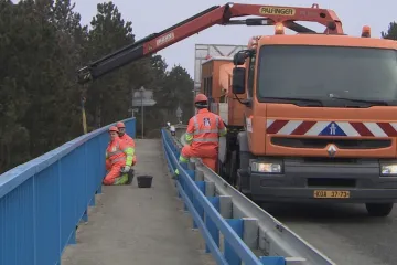 Bez zabezpečení a za bílého dne. Firmy i přes zákaz instalují plakáty na mosty
