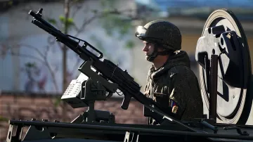 Ruský voják stojí ve vozidle jedoucím k Rudému náměstí
