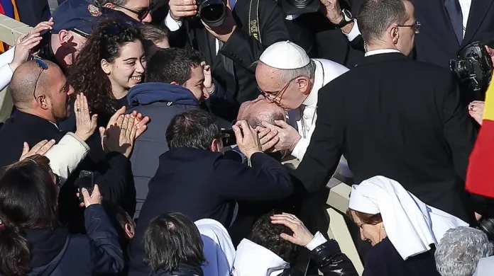 Papež líbá postiženého muže na Svatopetrském náměstí