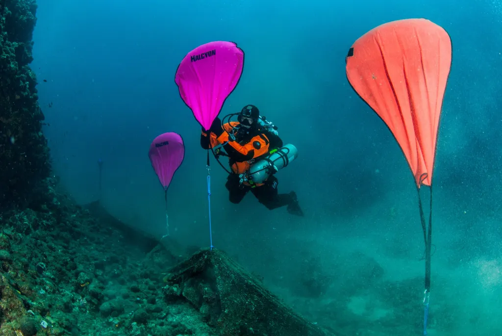 Nedaleko Chalkidiki speciální potápěči čistí dno od rybářských sítí pomocí balonů, do kterých se načerpá vzduch a ty následně vyzvednou zátěž k hladině