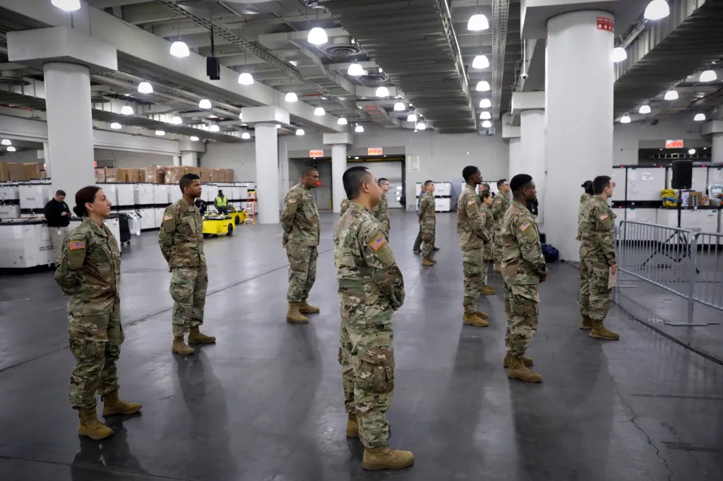 Guvernér Andrew Cuomo mluví v kongresovém centru v New Yorku k vojákům, kteří dodržují povinné rozestupy. Objekt bude přeměněn na nemocnici pro lidi postižené chorobou COVID-19