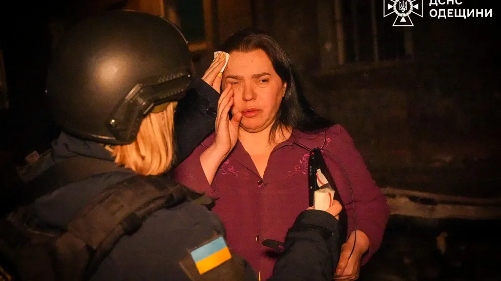 Záchranářka poskytuje pomoc obyvatelce Oděsy po ruském útoku drony na město
