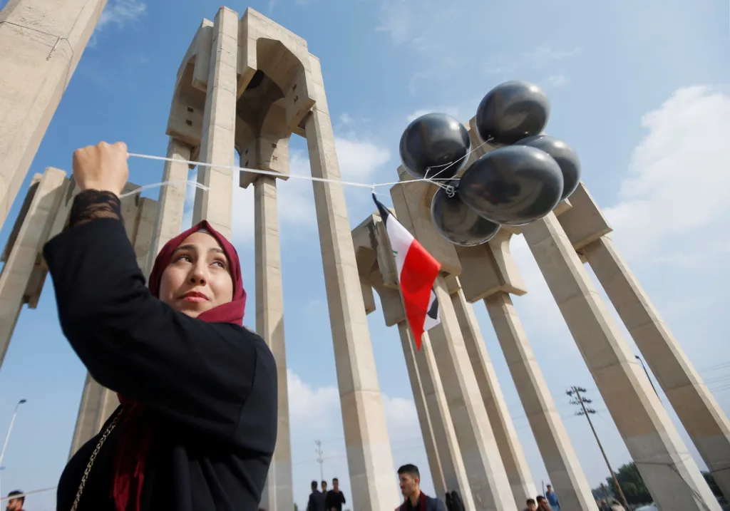 Studentka univerzity v irácké Basře nese balony na protivládním protestu 8. prosince 2019