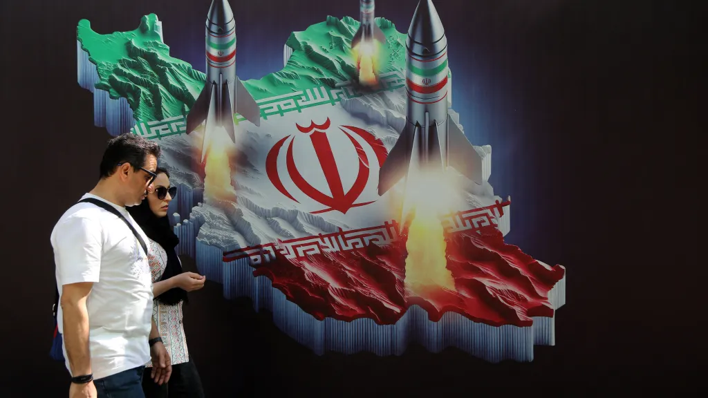 Obyvatelé Teheránu procházejí kolem nástěnné malby