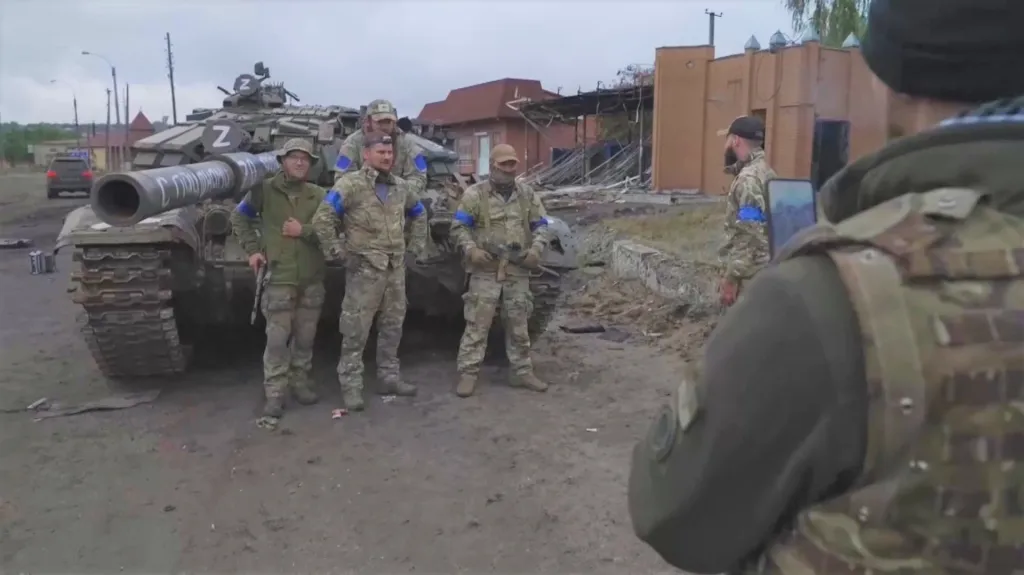 Ukrajinští vojáci stojí u opuštěného ruského tanku v Izjumu