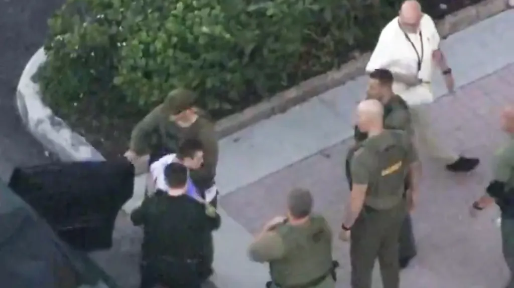 Policie odvádí útočníka z floridského Parklandu