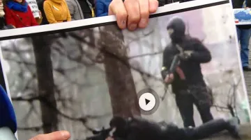 Demonstrant drží obrázek ukrajinských ostřelovačů