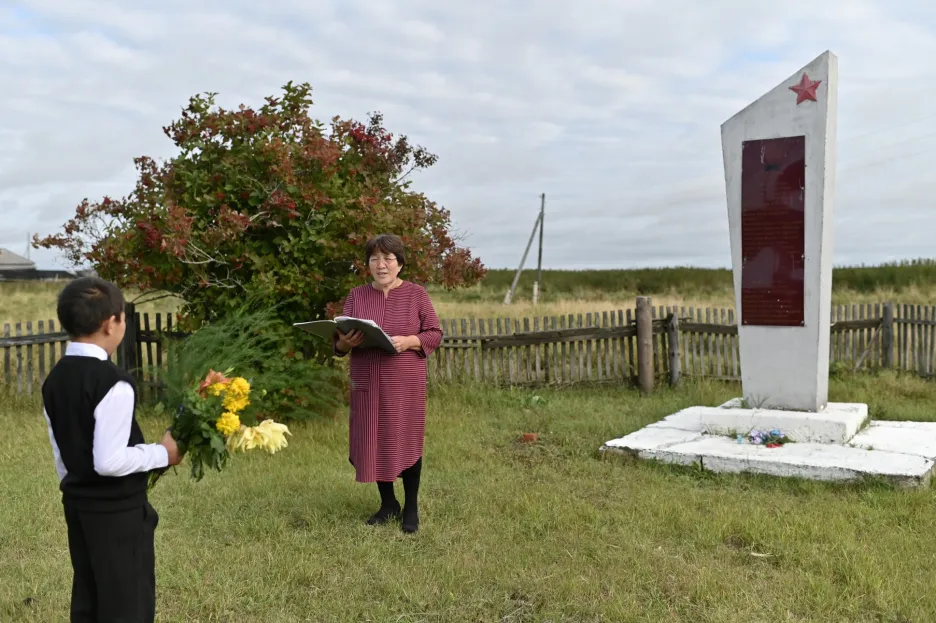 Devítiletý Ravil Izhmukhametov a učitelka Uminur Kučukovová (61 let) se účastní obřadu v první den nového školního roku vedle památníku druhé světové války