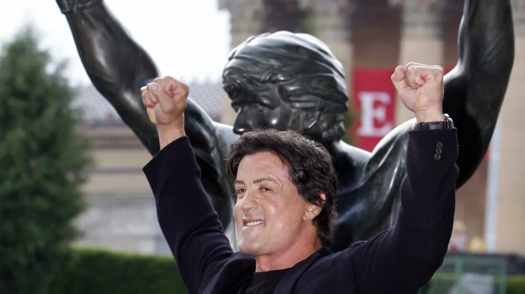 Sylvester Stallone pózuje před sochou z filmu Rocky III u Muzea umění ve Philadelphii (2006)