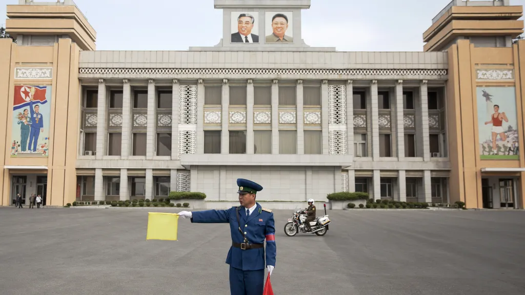 Policista řídí dopravu před jedním ze severokorejských stadionů