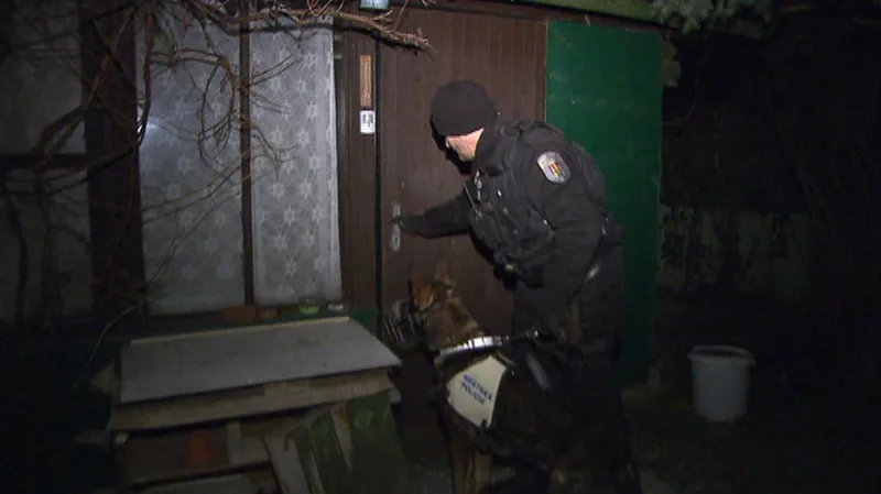 Policejní psovod kontroluje chatku