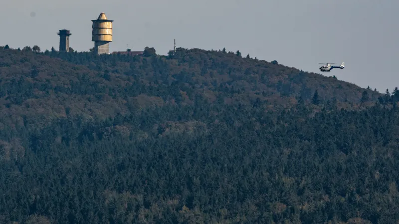 Policejní vrtulník monitoruje hustě zalesněný prostor v okolí Čerchova