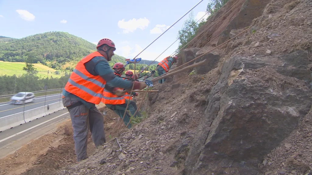 Horolezci zajišťují skálu u frekventované silnice
