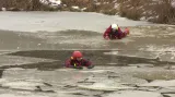 Jeden záchranář ve vodě, druhý se k němu snaží po ledu dostat